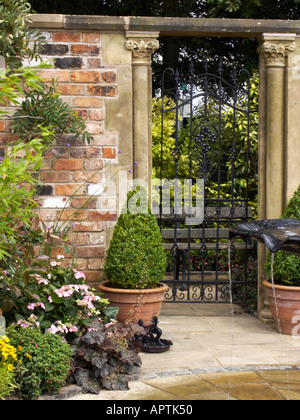 Tatton Blume zeigen traditionelle viktorianische Stadthaus Garten mit gewölbten Tor und Feld Formschnitt Stockfoto