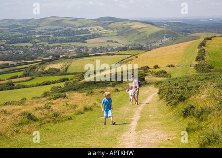 Eine Familie, die zu Fuß bergauf Brenscombe auf neun Barrow Down von Corfe Castle, Swanage Purbeck Dorset UK Stockfoto