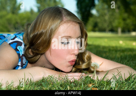 Niedliche Mädchen bläst Samen aus einem Löwenzahn Stockfoto