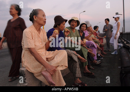 Frauen sammeln im Morgengrauen auf einer Brücke in Can Tho, Vietnam, Übung und Klatsch. Stockfoto