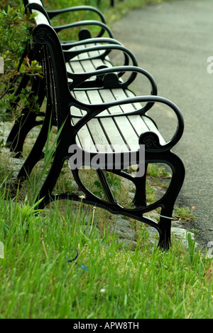 Eine schwarze aus Holz und Eisen Bank, stationiert auf der Seite der Gehweg sitzt im Liberty State Park in Jersey City, New Jersey. Stockfoto