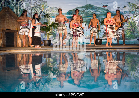 Menschen Durchführung traditioneller Maori Lieder und Tanz Unterhaltung auf der Bühne spiegelt sich in Wasserbecken Neuseeland Stockfoto