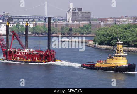 Schlepper Schleppboot Bau Barge oder Scow auf dem East River, New York City Roosevelt Island Lighthouse oder Welfare Island Lighthouse. MTA. USA Stockfoto