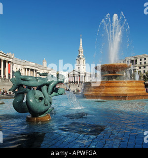 Skulptur in der berühmten Trafalgar Square Springbrunnen Wasser in der ursprünglichen Höhe & Kirche & Spire von St Martins auf den Feldern London England Großbritannien Stockfoto