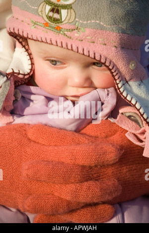 8 Monate altes Babymädchen eingehüllt in Winterkleidung Stockfoto