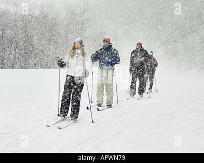 Skifahrer, die durch einen Schneesturm trekking Stockfoto