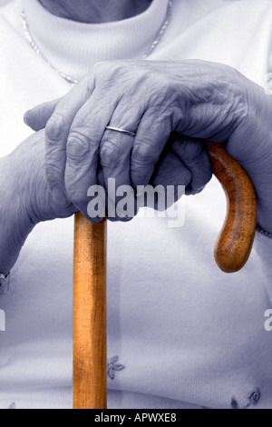 Octagenarian Dame. Die Hände ruhen auf dem Gehstock. Ältere Menschen. Unterkühlung Stockfoto