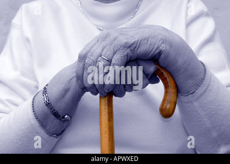 Octagenarian Dame. Die Hände ruhen auf dem Gehstock. Ältere Menschen. Unterkühlung Stockfoto