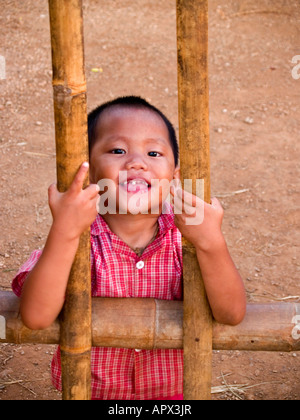 junge lächelnd hinter seinen Bambuszaun am Inle See in Myanmar Stockfoto