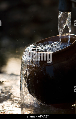 Füllen eine indische Tontopf mit sauberem Süßwasser eine Handpumpe Wasser in der indischen Landschaft. Andhra Pradesh, Indien Stockfoto