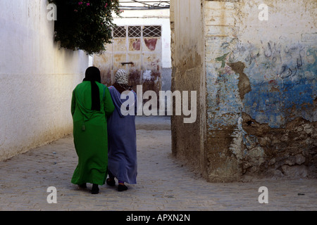 Zwei Frauen in traditioneller Kleidung gehen in Richtung einer Tür in Moulay Idriss Stockfoto