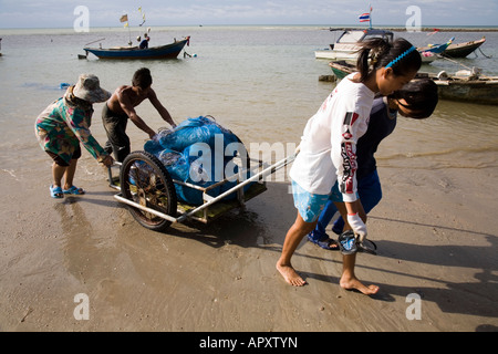 Frauen und Fischerfamilien transportieren Krebsnetze per Handwagen auf das Land. Phala Beach in der Nähe von Rayong, Thailand. Stockfoto