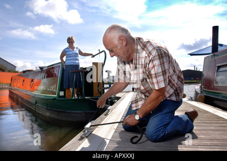 EIN PAAR AUF EINEM POLNISCHEN GEBAUT NARROWBOAT AM MÖNCH WIESE DOCK IN GLOUCESTER UK Stockfoto