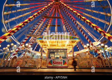 Ein Junge steht vor einem Riesenrad auf einer Kirmes namens "Funderland" in Dublin, Irland. Stockfoto