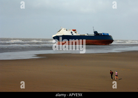 Ein paar jogging am Strand bei Cleveleys übergeben die betroffenen Ro-Ro-Fähre "Riverdance" Stockfoto