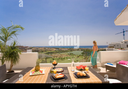 Junge Frau im Bikini und wickeln auf sonnigen Balkon mit Blick auf Golfplatz und Blick auf das Mittelmeer Stockfoto