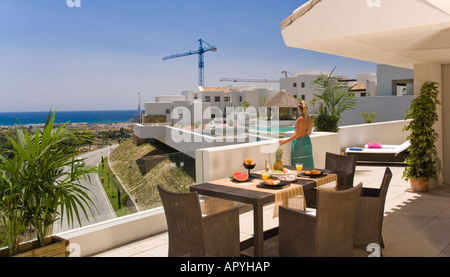 Junge Frau im Bikini und frühstücken mit Blick auf Meer-Packung auf Terrasse Stockfoto