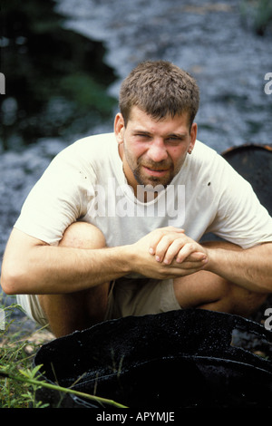 Fotograf sitzt neben einem Ölfass gefüllt mit Rohöl Abfall entsorgt der Ölindustrie auf Warani Land ecuadorianischen Amazonas Stockfoto