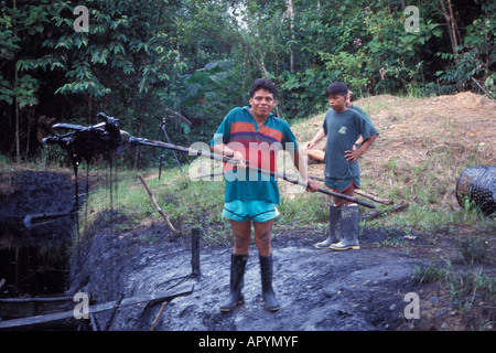 Warane Mann auf seinem Grundstück steht und schaut ein Tagebau gefüllt mit Rohöl Abfall entsorgt Ölindustrie ecuadorianischen Amazonas Stockfoto