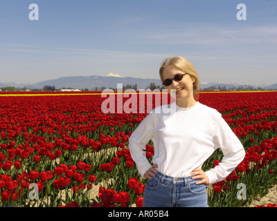 Frau im Bereich der roten Tulpen mit Mt Baker im Hintergrund Skagit Valley Mt Vernon Washington USA Model Release verfügbar Stockfoto