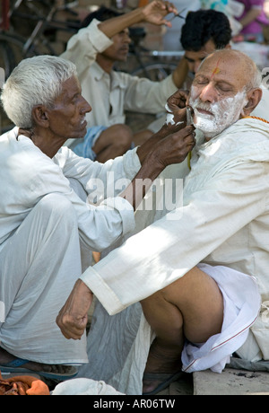 Straße Barbier. Assi Ghat. Varanasi. Indien Stockfoto