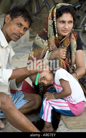 Straße Barbier rasieren des Kopfes eines jungen. Traditionelle hinduistische Reinigungsritual. Assi Ghat.Varanasi. NDIA Stockfoto