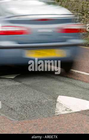 Ein Auto über eine Geschwindigkeit Buckel Stockfoto