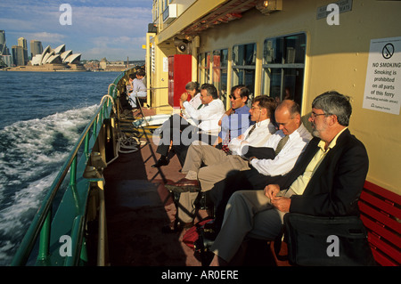 Pendler zur Arbeit am Morgen gehen Fähren, Sydney Opera im Hintergrund, Sydney, Sydney Harbour, New South Wales, Australien Stockfoto