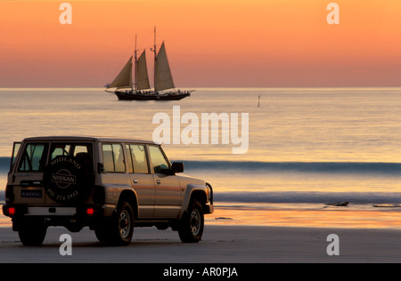 Ein Auto und Segelschiff im Abendlicht, Sonnenuntergang, Cable Beach, Broome, Western Australia, Australien Stockfoto