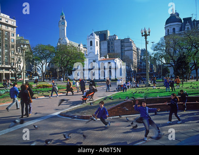Das Cabildo und Uhrturm über dem verspielten Kinder und Tauben in der Plaza de Mayo in Buenos Aires Stockfoto
