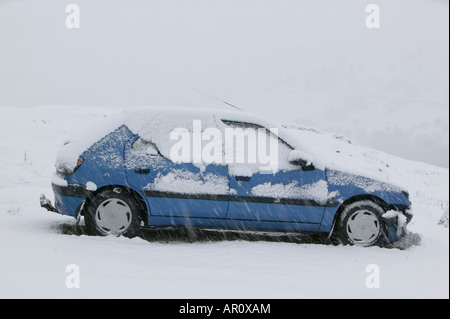 ein Auto verlassen auf Kirkstone Pass im Lake District in starkem Schneefall UK Stockfoto