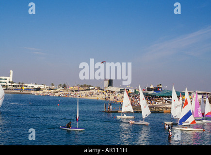 Segelboote mit großen Gruppe von Menschen versammelten sich am Strand im Meer gesehen. Stockfoto