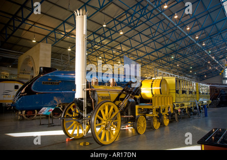 Stephenson's Rocket mit dem Mallard Train im Hintergrund der Großen Halle des National Railway Museum in York Stockfoto