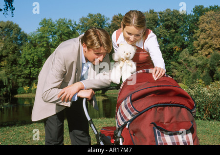 Outdoor-Tag Sommer Park Baum Bäume Gasse Wasser See Frau Mann 25 30 junge Pärchen paar blonde Blondinen langes Haar Lächeln Lächeln Stockfoto