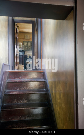 kleine hölzerne Treppe hinauf in ein Zimmer mit Antiquitäten Stockfoto