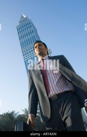 Junger Mann walking im Freien mit Wolkenkratzern im Hintergrund Stockfoto