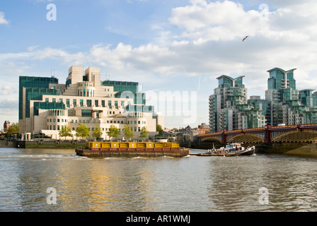 Horizontale Ansicht von einem Schlepper auf der Themse vor Gebäude aka der MI6 SIS Gebäude in Vauxhall an einem sonnigen Tag Stockfoto