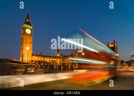 Horizontalen Weitwinkel ein Doppeldecker Bus fahren bestanden die Houses of Parliament und Big Ben in einer Unschärfe der Lichter in der Nacht Stockfoto