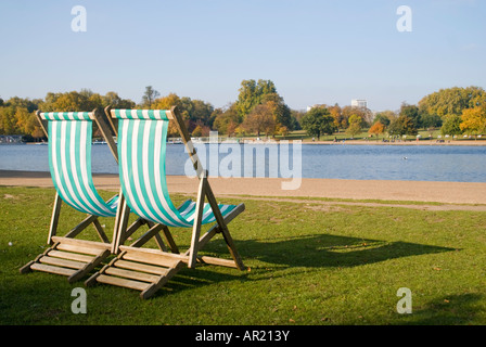 Horizontal dicht gestreift von zwei grünen und weißen hölzernen Liegestühle am See an einem sonnigen Tag Stockfoto