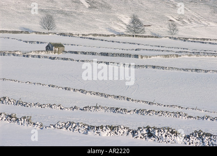 Eine Scheune in Schnee bedeckte Felder und Trockenmauern Peak District National Park Derbyshire England GB UK EU Europa Stockfoto