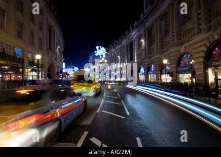 Horizontalen Weitwinkel von Regent St im Zentrum von London in der Nacht - ein Polizeiauto und Krankenwagen Zoomen bestanden in einer Unschärfe der Lichter. Stockfoto
