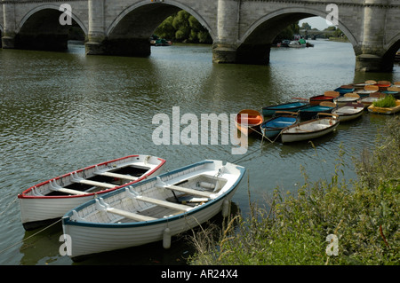 Bunte Boote vertäut am Fluss mit Richmond Bridge im Hintergrund Richmond upon Thames, Surrey England Stockfoto