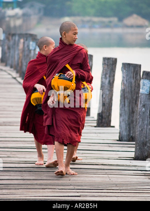 Trio von jungen Mönche tun ihr morgen Almosen rundet der U Klangkunst Brücke in Myanmar Stockfoto