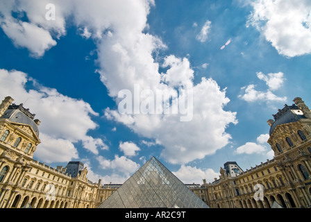 PARIS, Frankreich - Der Louvre in Paris, mit der berühmten glaspyramide im Zentrum an der Unterseite des Rahmens und Puffy clouds Overhead mit Copyspace. Stockfoto