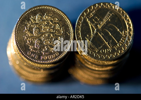 Zwei Stapel von britischen Pfund-Münzen auf blauem Hintergrund Stockfoto