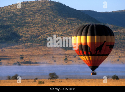 Südafrika Pilanesburg Game Reserve Hot Air Ballon erhebt sich über Nebel bedeckt See bei Sonnenaufgang in der Nähe von Sun City Stockfoto