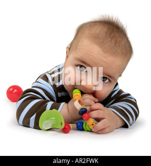 Baby mit Spielzeug auf dem Bauch liegend Stockfoto