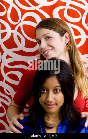 zwei Freundinnen, eine hellhäutige, blonde Frau und ihre dunkelhäutige und dunkelhaarige Freundin Stockfoto