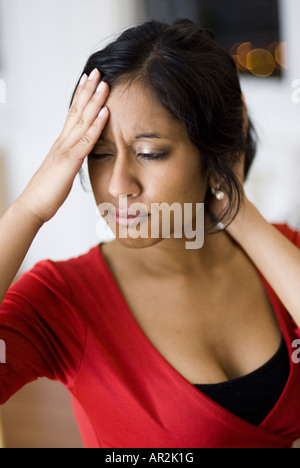 dunkelhäutige Frau mit schwarzen Haaren mit Kopfschmerzen Stockfoto