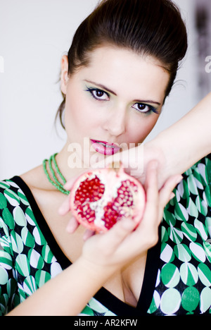 attraktive Frau, die Hälfte der Granatapfel Stockfoto